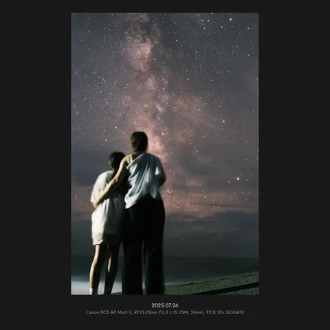 A photo of two people looking up at the Milky Way, exported in a 1:1 frame
