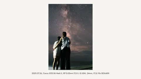 A photo of two people looking up at the Milky Way, exported in a 16:9 frame